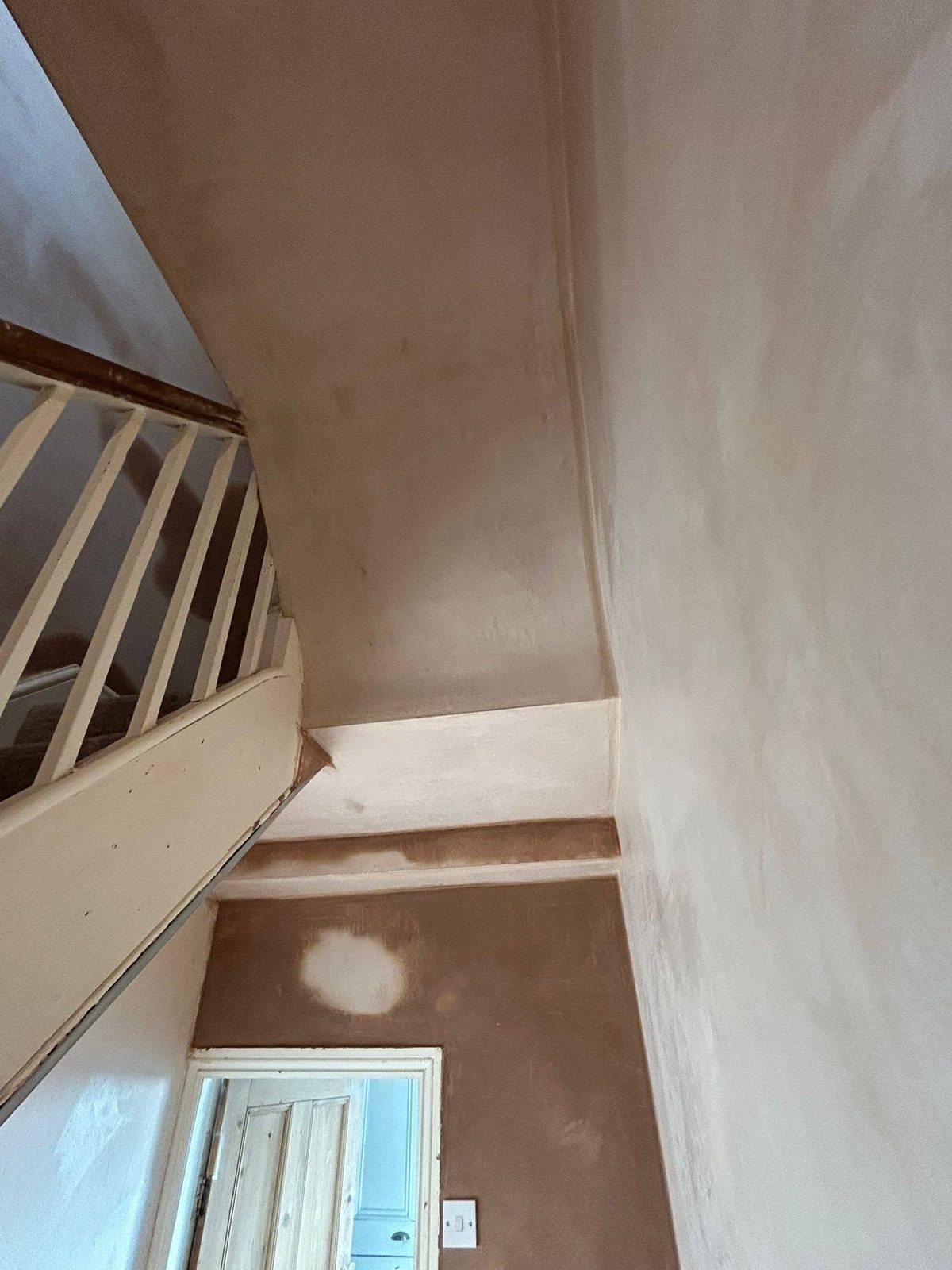 The landing after: smooth fresh plaster down to the stairs and front door