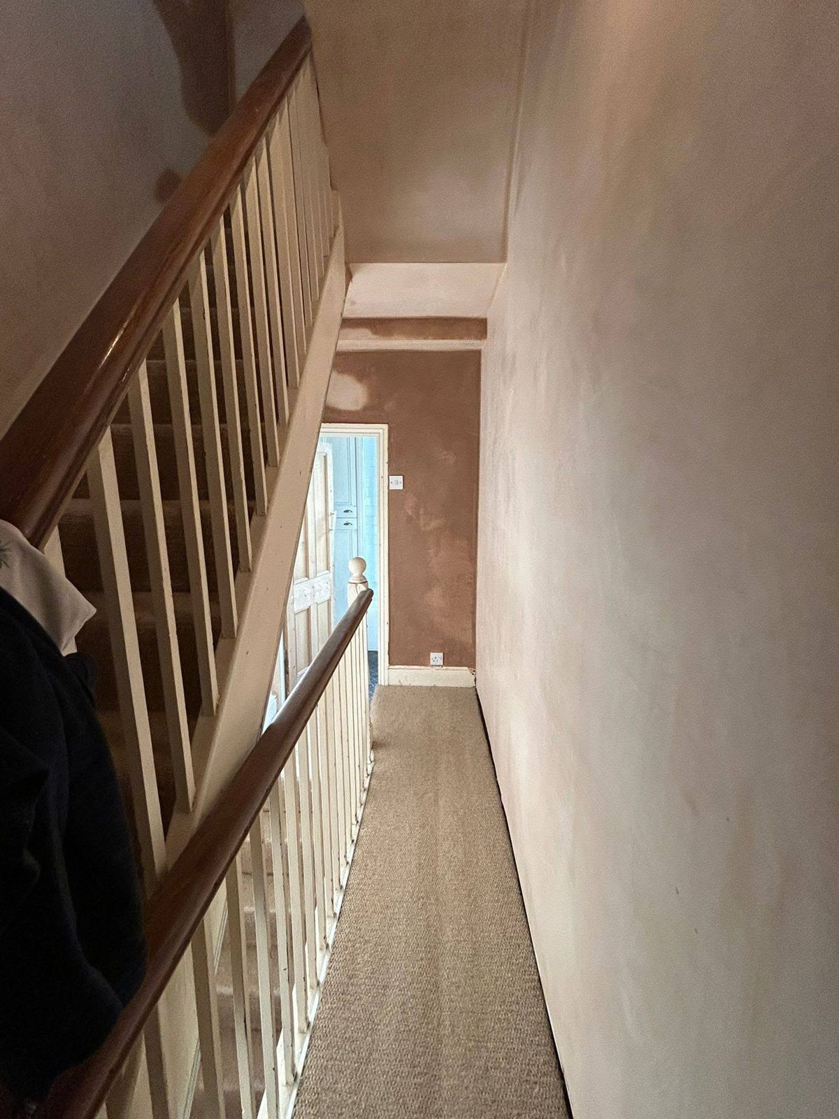 The stairwell after: walls and ceiling freshly skimmed in pink plaster