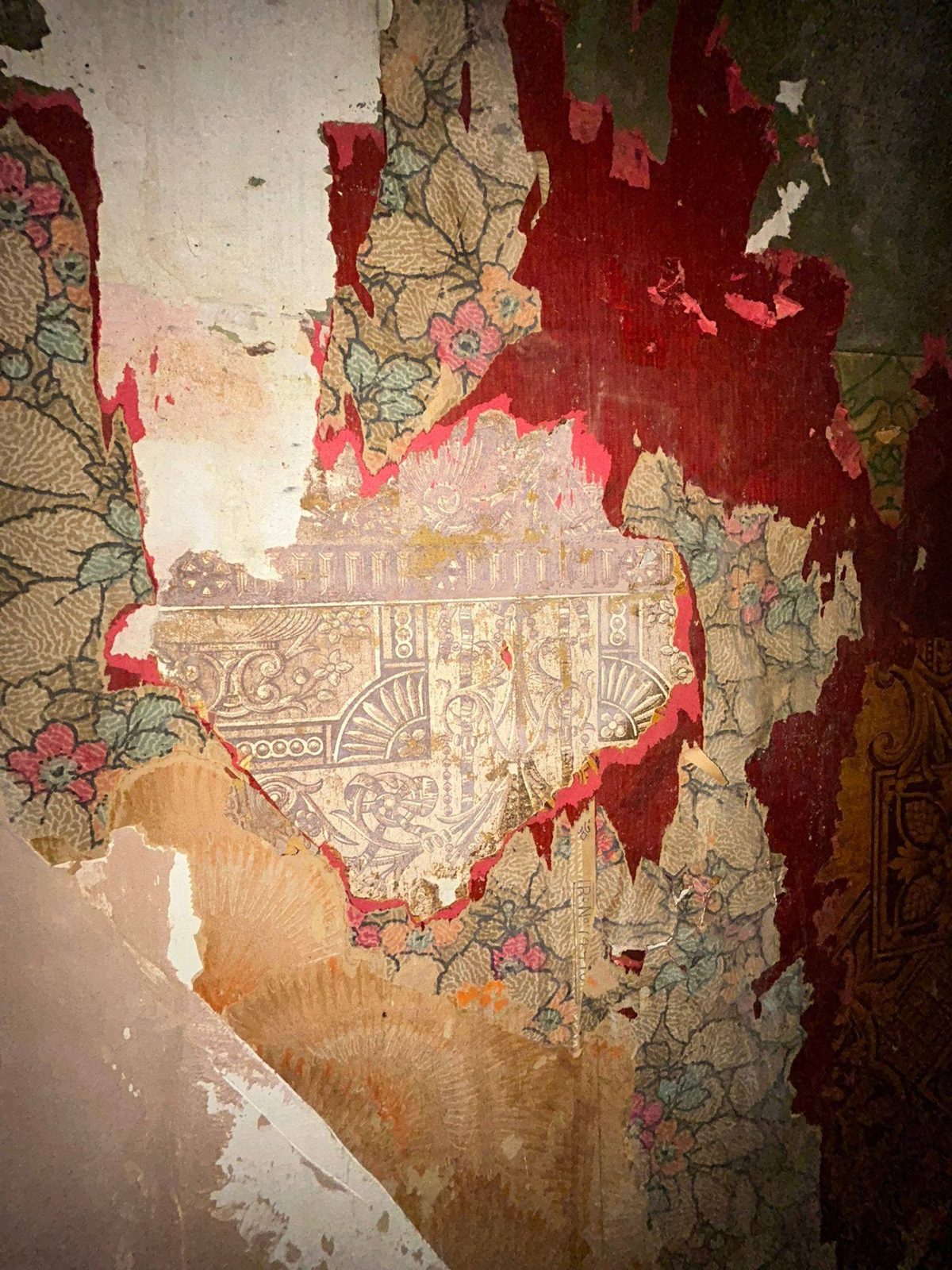Close-up of several layers of old wallpaper peeling off a wall
