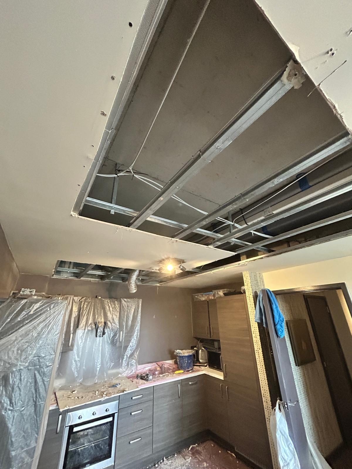 Kitchen ceiling opened up and boarded, worktops covered in plastic sheeting